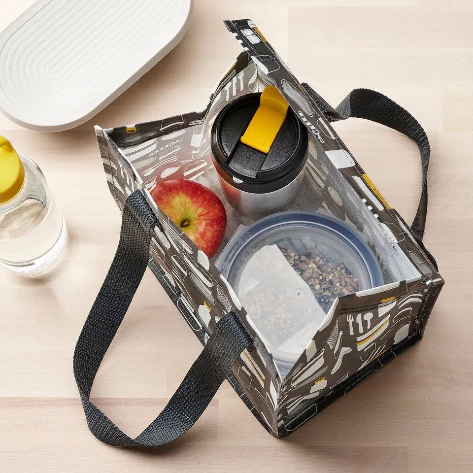 Insulated lunch bag with thermos, apple, and snack containers, designed for travel and commuting.