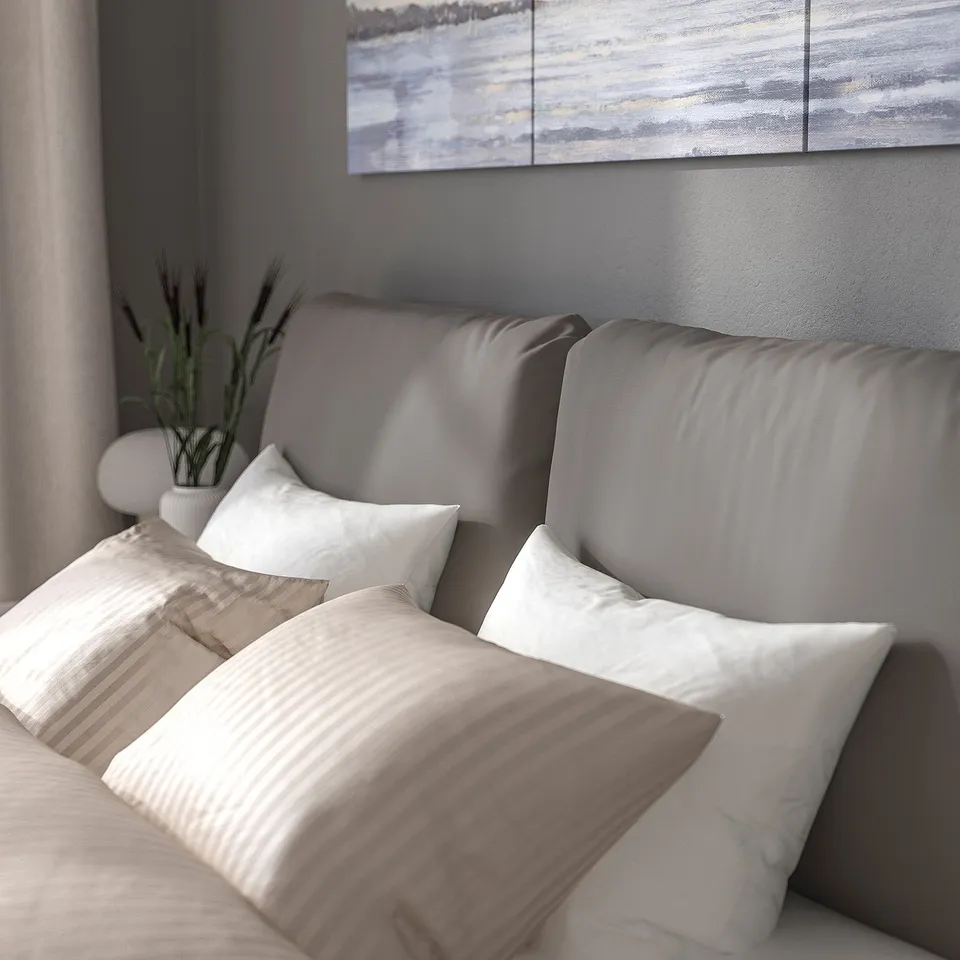 Modern bed with sloped headboard & 2 pillows, machine-washable fabric.