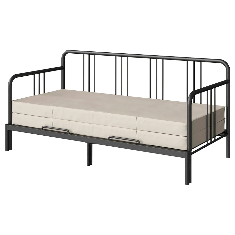A FYRESDAL day-bed in black with a beige mattress. It a metal frame with vertical bars and can convert into a sofa or double bed.