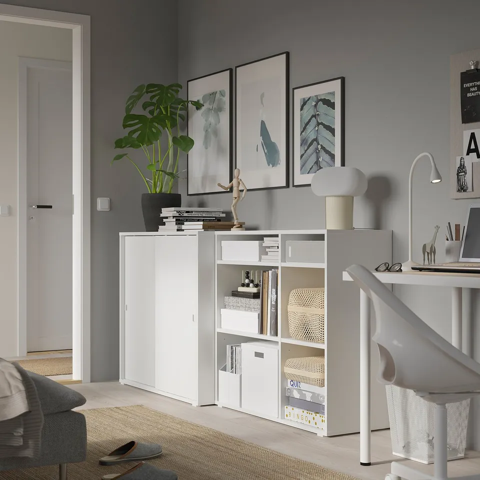Modern living space with white storage, decor, and plants.