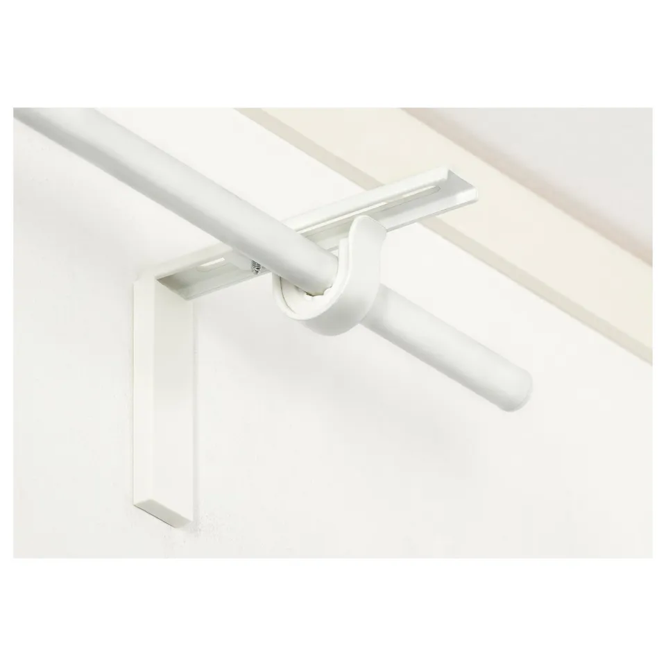 White adjustable curtain rod holder mounted on white wall. Allows versatile curtain hanging options near or far from the window.