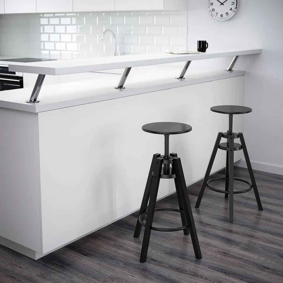 Modern kitchen with two adjustable black DALFRED bar stools under a white counter.