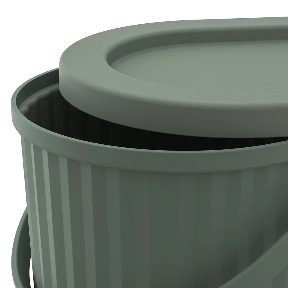 Closeup of green DAMMÄNG recycling bin, showing its sturdy, ridged texture and lid with secure edge.