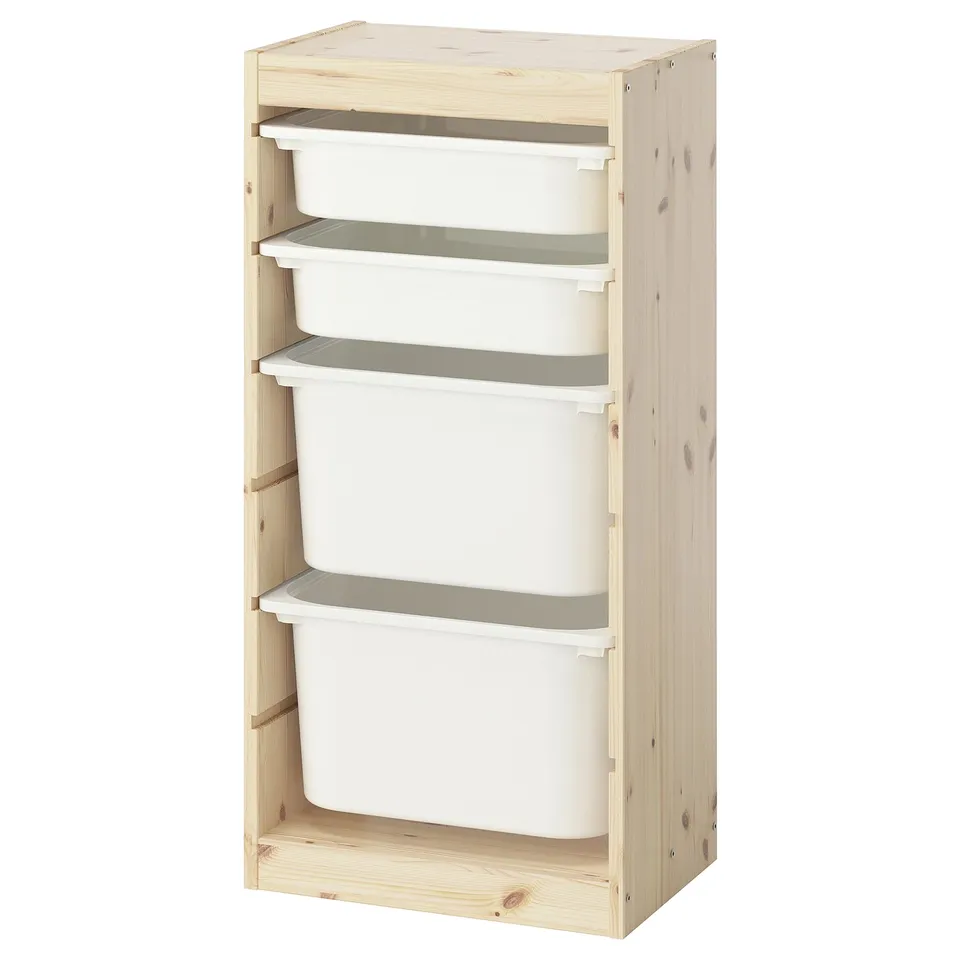 An IKEA TROFAST light pine wooden storage unit with four white plastic drawers. It is tall and rectangular, designed for organising childrens toys.
