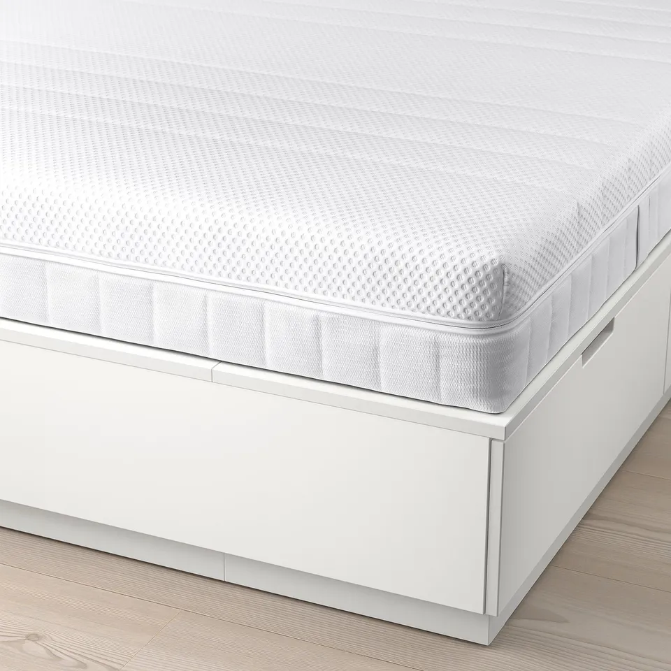 White NORDLI bed frame with six under-bed drawers, showcasing its storage capacity.