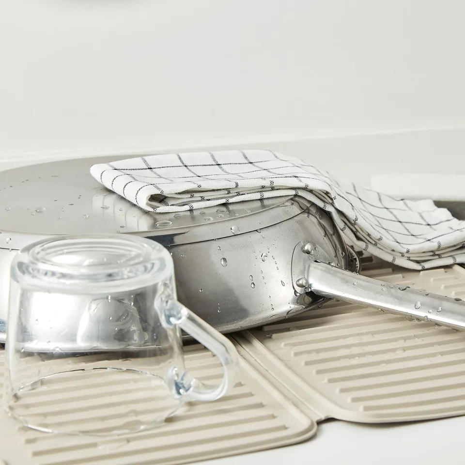 Dish drying mat with grooves and items.