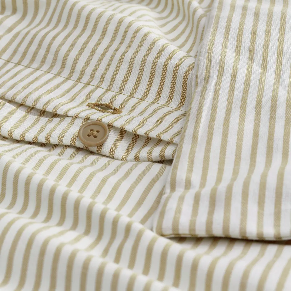 A beige and white striped shirt with a visible button and stitching details.